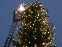 Kerstman steekt de kerstboom aan